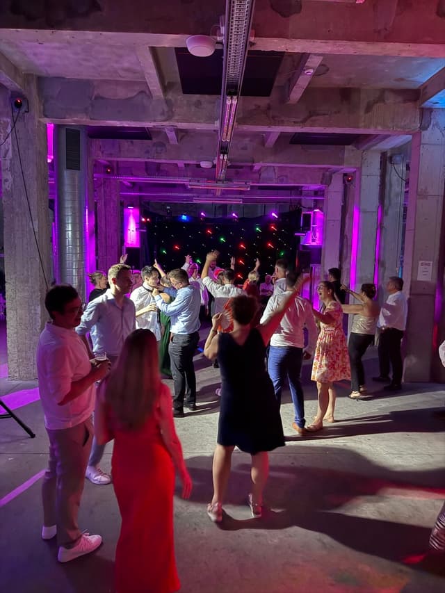 DJ Stijn draait muziek voor een enthousiast publiek op een trouwfeest